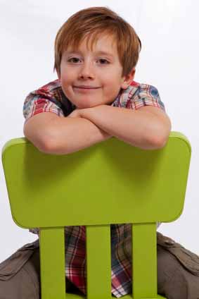 Young Boy Sitting On A Chair Backwards