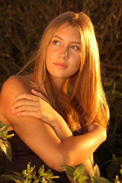 Female Posing With Her Arms Folded In Evening Sunlight